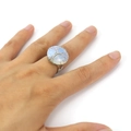 Detail of handmade silver wire wrapped Tree of Life ring with white opal stone on finger - Opal