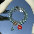 Exquisite blue glass bead bracelet featuring a red flower charm on a reflective mirror - S060-blue Bracelet With Bright Red Pendant And Daisy Design #sz531