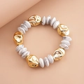 Detalle de cuentas doradas irregulares y perlas de mármol en una pulsera de moda - Blanco Grisáceo