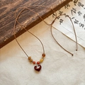 Collana etnica con perle di cocco e ciondolo a cuore Saturno rosso bordeaux - Cuore Caffè