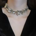 Detailansicht der funkelnden Strasshalskette in Wassertropfenform am Hals der Frau - Silberne Halskette im Übertriebenen Strass-Stil
