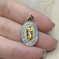 Close-up of golden oval religious Jesus pendant with shell inlay and zircon border - Blue