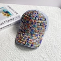 Detalle de perlas de colores y tachuelas plateadas en una gorra de béisbol azul claro - Adulto, Ajustable / Azul