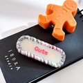 Oval knitted acetate hair clip with pink 'Cute' text and multicolor woven border - Oval-Cream White