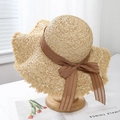 Detail of raffia sun hat with wide frayed brim and brown striped ribbon bow decoration - Coffee Ribbon