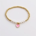 Detail of beaded bracelet with gold copper beads, white pearls, and pink enamel heart charm - Pink