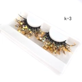 Detail view of 25mm 3D false eyelashes with yellow glitter on a white K-3 tray - K-03 [Glowing]