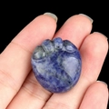 Deep blue natural agate stone paw print figurine held in hand to show scale - Blue Sodalite