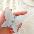 Light blue frosted butterfly hair claw clip with internal metal spring held in hand - Blue Butterfly Claw Clip / Blue