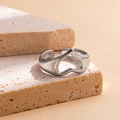 Close-up of silver hollow heart-shaped open ring on a textured stone pedestal - Heart Steel Color 59