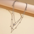 Macro detail of multi-layered silver necklace with star and crescent moon pendants - Silver