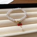 Elegant gold-plated pearl bracelet featuring a red cherry enamel charm and lobster clasp - Cherry