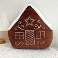 Detailed close-up of a gingerbread house plush pillow with festive embroidery on soft fabric - Snow House/Gingerbread House Style
