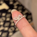 Close-up of pink pear-cut gemstone ring with micro-pave diamonds on silver band - Leaf Design Pink Zirconia