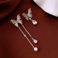Detailed macro of asymmetric bow earrings with crystal tassels, pearls, and shell wings - Asymmetric Butterfly Zircon (16#)