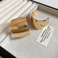 Detail van brede vergulde C-ring oorbellen op een beige fluwelen sieradendisplay - IJzeren Lichaam + S925 Zilveren Pin / Goud