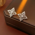 Dettaglio degli orecchini a fiore traforati in argento con micro-pavé di zirconi lucidi - Argento