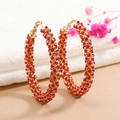 Close-up of large gold-tone hoop earrings fully set with sparkling red crystals - Red KC Gold