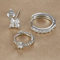 Three-piece silver earring set with clover stud and zirconia hoops on fabric background - Silver (Y26069)