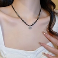 Detail of beaded necklace with black beads and a round metal pendant on a model's neck - Bamboo Bead Style (Black)