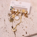 Golden stainless steel earring set featuring clover, evil eye, and flower motifs - Style 9