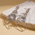Elegant silver hammered multi-circle dangle earrings displayed on white stone prop - Earring Post (Copper Style) / Silver