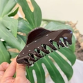 Detail of a large 12cm glossy dark coffee butterfly hair claw clip with a sleek finish - Chocolate