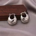 Polished silver teardrop hoop earrings with high-gloss finish on a premium display stand - E-059---Platinum
