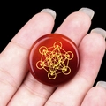 Round red agate stone pendant with golden Metatron cube engraving, handheld view - Red Agate