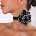 Detalle de una gargantilla de camelia negra con cristales brillantes en una modelo - Negro