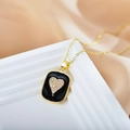 Close-up of black enamel heart pendant with crystals on a golden chain necklace - Black