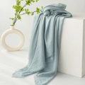 Light blue cotton linen scarf with fringe edges displayed on white decorative props - Gray Blue