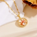 Detailed close-up of a gold sun pendant necklace with red enamel and opal center stone - Enamel Sun Opal Style (XL10057)