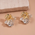 Two-tone metallic flower earrings with sparkling cubic zirconia on a natural rock display - Gold and Silver Two-Tone