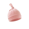Detailed view of a soft pink newborn knotted hat featuring smooth cotton fabric texture - Shrimp Pink