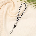 Minimalist black and white braided phone strap with silver ring on beige fabric - Black