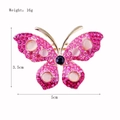 Detailed rhinestone butterfly brooch with pink cat's eye stone measuring 5cm x 3.5cm - Pink