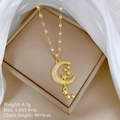 Dettaglio della collana con luna e stella oro e misure su sfondo in seta bianca - Stile Luna e Stella (A218)