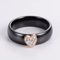 Detail view of a black ceramic ring with a gold heart pendant and micro-set diamonds - US 6 / Rose Gold