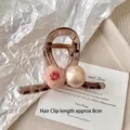 Detailed macro view of an 8cm brown resin hair claw clip with floral and pearl accents - Medium Pink Flower Pearl Clip