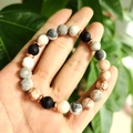 Detail of lava stone and turquoise beaded bracelet set with a rose gold crown charm - Black Lava Stone Marble Texture Metal Ball Bracelet
