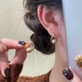 Elegant gold metal hoop earrings with round pearl charms worn by a model - A2054 Rose Gold Pearl Hoop
