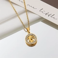 Close-up of a gold Virgin Mary pendant necklace with white zircon border on satin - Virgin Mary