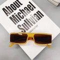 Retro amber square frame sunglasses with dark brown lenses on minimalist book prop - Jelly Yellow