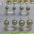 Detail view of pearl earrings in four sizes with golden stainless steel leverback hooks - 6mm / Gold