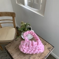 Detailed texture of pink hand-woven cotton thread tote bag on a rustic wooden table - Pink