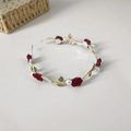 Elegante diadema dorada con rosas rojo oscuro, hojas verdes y perlas blancas sobre fondo blanco - Hojas Verdes y Flores Rojas