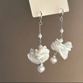 Detail of cream white flower pearl tassel earrings with silver finish on dark background - 23# Ear Clip - White (Pearl Shell Flower Tassel)