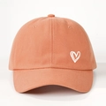 Detail of coral cotton baseball cap showing white heart embroidery and twill texture - One Size / Orange
