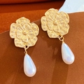 Primer plano de pendientes de flor dorada con elegantes perlas blancas - Estilo Flor de Perla Dorada (N-402)